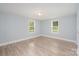 Bright bedroom features wood-look flooring and two windows at 870 Family Dr, Midland, NC 28107