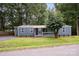 Charming single-story home with blue siding, a metal roof, and a well-manicured lawn surrounded by mature trees at 870 Family Dr, Midland, NC 28107