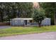 Charming single-story home with blue siding, a metal roof, and a well-manicured lawn surrounded by mature trees at 870 Family Dr, Midland, NC 28107