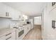 Well-lit kitchen featuring white cabinets and appliances, complemented by neutral vinyl flooring and lots of cabinet space at 870 Family Dr, Midland, NC 28107