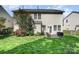 Rear exterior view showcasing a well-maintained yard, cozy patio, and the home's siding and windows at 10237 Broken Stone Ct, Charlotte, NC 28214
