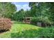 Spacious backyard with lush green grass, privacy fence, and a charming pergola-covered deck for outdoor entertaining at 10237 Broken Stone Ct, Charlotte, NC 28214