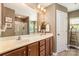 Well-lit bathroom featuring a double vanity, framed mirror, and a shower behind a glass door at 10237 Broken Stone Ct, Charlotte, NC 28214