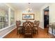 Formal dining room with hardwood floors, chandelier, large mirror and seating for six at 10237 Broken Stone Ct, Charlotte, NC 28214