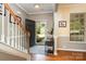 Welcoming foyer featuring hardwood floors, staircase, and an open door, offering a glimpse of the outdoors at 10237 Broken Stone Ct, Charlotte, NC 28214
