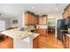 Beautiful kitchen featuring hardwood floors, granite countertops, wood cabinets and black appliances at 10237 Broken Stone Ct, Charlotte, NC 28214