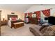 Large primary bedroom with vaulted ceiling, dark furniture, carpet, and home office area at 10237 Broken Stone Ct, Charlotte, NC 28214