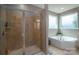 Bathroom featuring a glass-enclosed shower and a soaking tub by bright windows at 104 Wingstem Ct, Mooresville, NC 28117