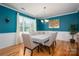Beautiful dining room featuring wainscoting, hardwood floors, and a stylish chandelier at 104 Wingstem Ct, Mooresville, NC 28117