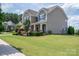 Attractive two-story home with a covered front porch, showcasing curb appeal with a green lawn at 104 Wingstem Ct, Mooresville, NC 28117