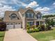 Charming two-story home featuring a two-car garage, stone accents, and manicured landscaping at 104 Wingstem Ct, Mooresville, NC 28117