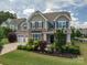 Charming home featuring stone accents, lush landscaping, and a welcoming front porch at 104 Wingstem Ct, Mooresville, NC 28117