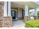 Charming front porch with stone pillars, a black front door, and well-maintained landscaping at 104 Wingstem Ct, Mooresville, NC 28117