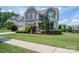 Beautiful two-story home with a well-maintained lawn and landscaping, including trees and shrubs at 104 Wingstem Ct, Mooresville, NC 28117