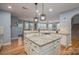 Open kitchen with granite countertops, white cabinets, and a large island at 104 Wingstem Ct, Mooresville, NC 28117