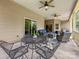Relaxing covered patio featuring ceiling fans, comfortable seating, and ample space for outdoor enjoyment at 106 Pier Point Dr, Stony Point, NC 28678
