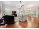 Open-concept living area with hardwood floors, multiple seating options, and a view of the dining area and backyard at 106 Pier Point Dr, Stony Point, NC 28678