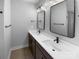 Modern bathroom with double sinks, black fixtures, vanity lighting and mirrors at 11211 James Coy Rd, Huntersville, NC 28078