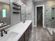 Modern bathroom featuring double sinks, a quartz countertop, and a walk-in shower with wood-look tile surround at 11211 James Coy Rd, Huntersville, NC 28078