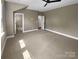 Neutral colored bedroom with modern ceiling fan and carpet, showing doorways to additional rooms at 11211 James Coy Rd, Huntersville, NC 28078