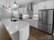 Modern kitchen with stainless steel appliances, gray tile backsplash, and a large island with quartz countertops at 11211 James Coy Rd, Huntersville, NC 28078