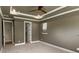 Spacious bedroom featuring a tray ceiling with recessed lighting and ceiling fan, and ensuite bathroom at 11211 James Coy Rd, Huntersville, NC 28078