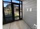 View from an enclosed patio with black framed windows and doors overlooking the landscaped backyard at 11211 James Coy Rd, Huntersville, NC 28078