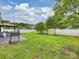 Spacious backyard featuring a lush lawn, mature trees, privacy fence, and patio with a grill at 11332 Anna Rose Rd, Charlotte, NC 28273