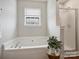 Bright bathroom featuring a soaking tub and a glass-enclosed shower at 11332 Anna Rose Rd, Charlotte, NC 28273