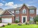 Charming two-story brick home with landscaped front yard and attached two-car garage at 11332 Anna Rose Rd, Charlotte, NC 28273