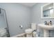 Powder bathroom with sleek fixtures, a pedestal sink, modern mirror and blue wall paint at 135 Oak Creek Dr, Rockwell, NC 28138