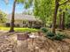 Backyard featuring gravel area, fire pit and outdoor seating with deck in background at 13600 Seastone Ln, Pineville, NC 28134
