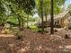 View of home's rear exterior with backyard, deck, and lush, tree-filled surroundings at 13600 Seastone Ln, Pineville, NC 28134