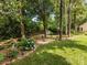 Landscaped backyard with mature trees, shed and small table with chairs at 13600 Seastone Ln, Pineville, NC 28134