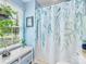 Charming bathroom featuring a floral shower curtain and bright natural light from the window at 13600 Seastone Ln, Pineville, NC 28134