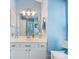 Light and airy bathroom features a large mirror, white vanity, and blue accent wall at 13600 Seastone Ln, Pineville, NC 28134