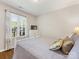 Bright bedroom featuring a white bed frame, hardwood floors, and a large sunny window at 13600 Seastone Ln, Pineville, NC 28134