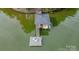 Aerial view of a private dock with a boat lift, surrounded by serene water and lush greenery at 18205 Royal Oak Rd, Charlotte, NC 28278