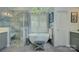 Luxurious bathroom with freestanding tub, glass-enclosed shower, gray vanity, and natural light at 18205 Royal Oak Rd, Charlotte, NC 28278