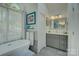 Bright bathroom featuring a soaking tub, modern gray vanity, and a decorative mirror at 18205 Royal Oak Rd, Charlotte, NC 28278