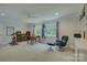 Large bonus room with a desk, shelving, an exercise bike, and a comfortable sitting area by bright windows at 18205 Royal Oak Rd, Charlotte, NC 28278