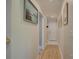 Bright hallway featuring hardwood floors, neutral walls with decorative paintings, and a white front door at 18205 Royal Oak Rd, Charlotte, NC 28278