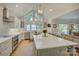 Open-concept kitchen with large island, white cabinetry, stainless steel appliances, and lake views at 18205 Royal Oak Rd, Charlotte, NC 28278