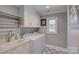 Well-organized laundry room with white cabinets, modern appliances, sink, and decorative tile flooring at 18205 Royal Oak Rd, Charlotte, NC 28278