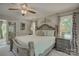 Serene main bedroom with ornate bed frame, neutral decor, and natural light from surrounding windows at 18205 Royal Oak Rd, Charlotte, NC 28278