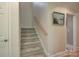 Carpeted stairway with wooden handrail and neutral walls leading to the upper level at 18205 Royal Oak Rd, Charlotte, NC 28278