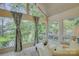 Bright sunroom with vaulted ceilings, large windows offering lake views, and comfortable seating area at 18205 Royal Oak Rd, Charlotte, NC 28278