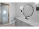 A bathroom with a glass shower, sleek fixtures, and a stylish round mirror at 19329 Watermark Dr # 422, Cornelius, NC 28031