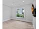 This bedroom features neutral walls, light-toned floors, a ceiling fan, and a view of the outside at 19329 Watermark Dr # 422, Cornelius, NC 28031