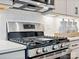 Close-up of a stainless steel range with modern backsplash and decor in this new kitchen at 223 Halemarg Dr, Belmont, NC 28012